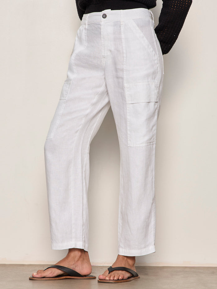 Wearing Sanctuary Clothing’s boyfriend utility pant in white, paired with a black long-sleeve top and black sandals. Only the lower half is visible, set against a plain light background.