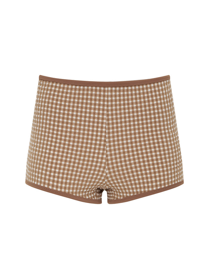 The boyshort bikini bottom toasted coconut by Sanctuary Clothing features a brown and white checkered pattern with brown trim at the waistband and leg openings, shown against a white background.