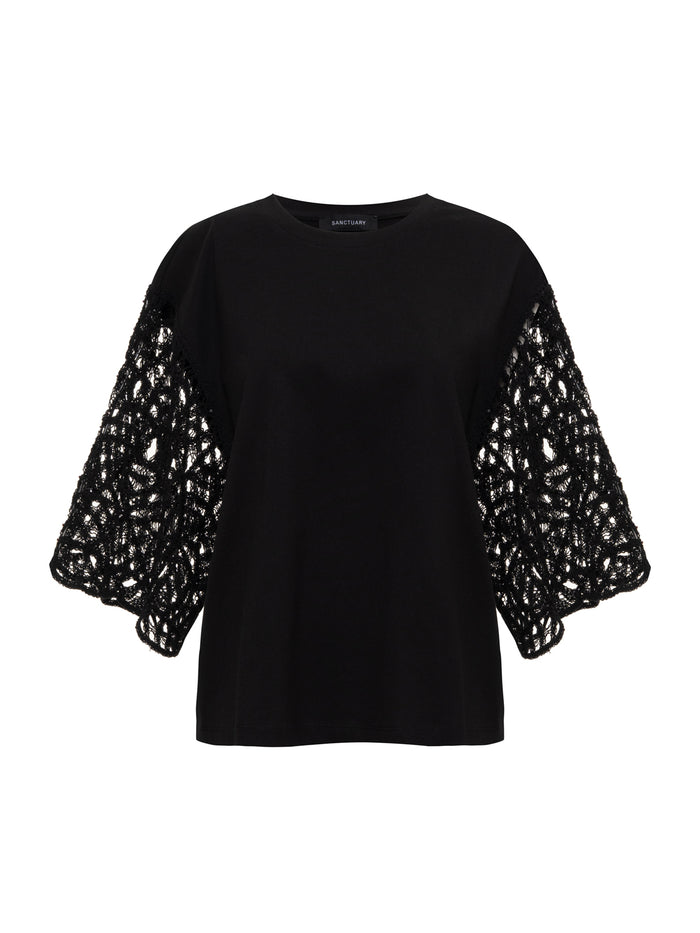 The Sanctuary Clothing crochet sleeve belle tee in black features wide lace-patterned short sleeves and a solid fabric torso, shown against a white background.