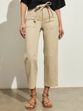 A person wearing the Sanctuary Clothing foundry pant khaki, paired with a black top and brown strappy sandals, stands against a light background.