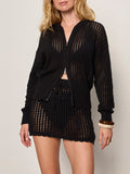 A woman wears the Sanctuary Clothing laguna openwork bomber in black (petite sizing) with a matching mini skirt, both featuring a sheer crochet knit. She has wavy blonde hair and accessorizes with a bangle bracelet.