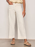 A person is shown from the waist down wearing Sanctuary Clothing's soft marine wide leg crop pant collagen in off-white, styled with a beige top and tan flat sandals with gold buckles against a plain background.