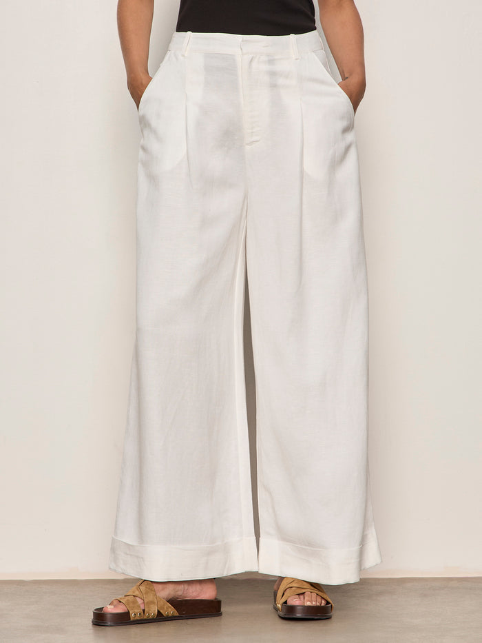 Person wearing white wide-leg pants on a plain background