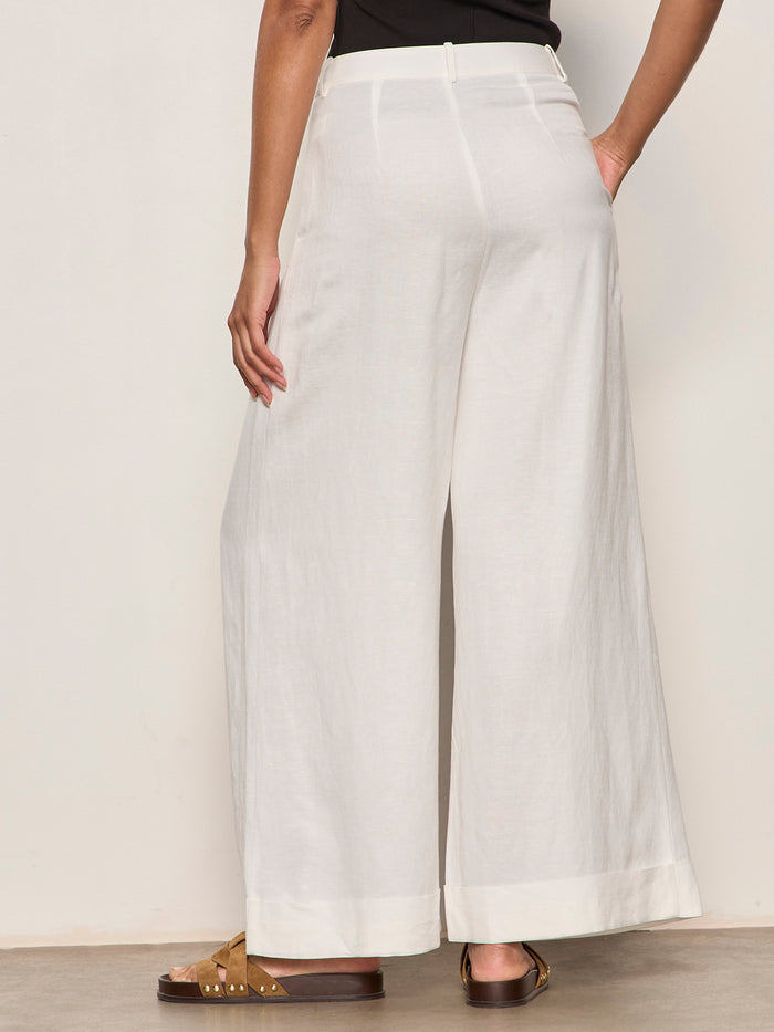 Person wearing white wide-leg pants on a plain background