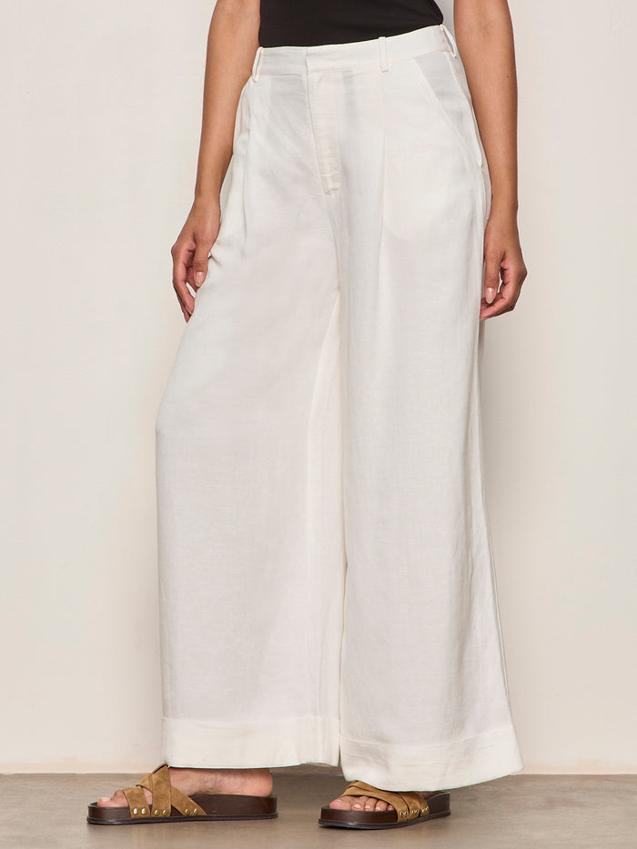 Person wearing white wide-leg pants on a plain background