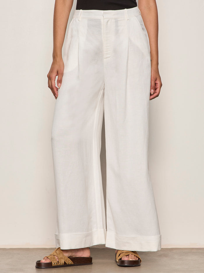 Person wearing white wide-leg pants on a plain background