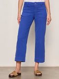 The lower half of a person is shown wearing Sanctuary Clothing's the marine luminous blue cropped pants with front patch pockets and brown sandals, set against a plain light-colored background.